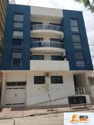 a blue and white building with a parking garage at Departamento Sorrentos in Villa Carlos Paz