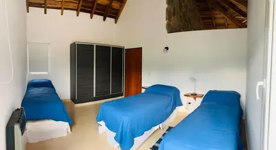 two beds in a room with blue sheets at CABAÑA MAR - FINCA PUDUAM in Villa General Belgrano
