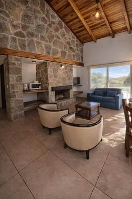a living room with couches and a stone fireplace at CABAÑA MAR - FINCA PUDUAM in Villa General Belgrano
