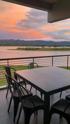 a table and chairs on a balcony with a view of the water at Dpto The View, Puerto del Águila Lago Los Molinos in Potrero de Garay