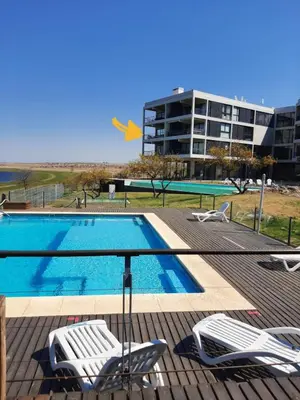 a swimming pool with chairs and a building at Dpto The View, Puerto del Águila Lago Los Molinos in Potrero de Garay
