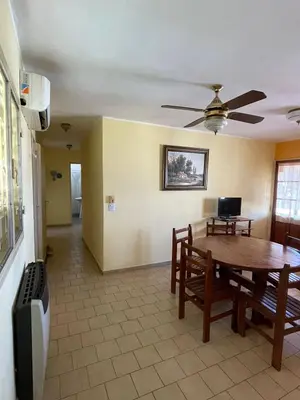 a dining room with a table and a tv at terrazas del Tajamar in Alta Gracia