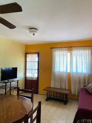 a living room with a table and a tv at terrazas del Tajamar in Alta Gracia