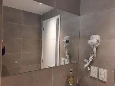 a bathroom with a mirror and a hair dryer at APART VITTA in Río Cuarto