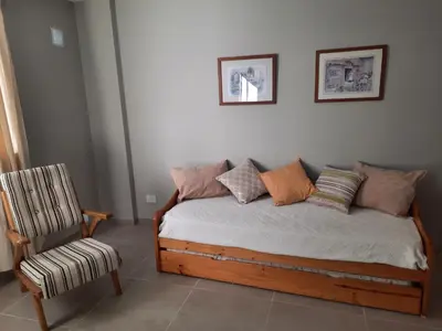 a bed with pillows and a chair in a room at APART VITTA in Río Cuarto