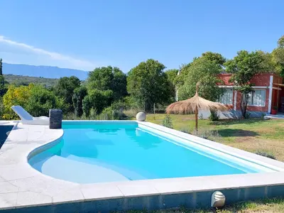 a large swimming pool in a yard with a house at Los Molles Suites -Solo 2 Pax- in Mina Clavero