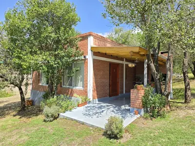 a small brick house with a porch with awning at Los Molles Suites -Solo 2 Pax- in Mina Clavero