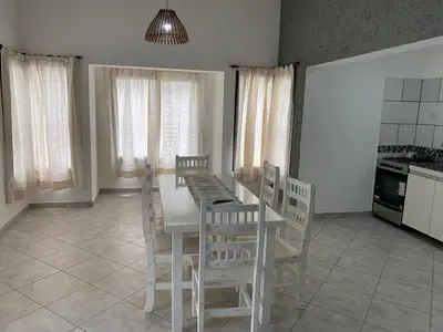 a dining room with a white table and chairs at Cabaña Siete Colores II in Santa Rosa de Calamuchita
