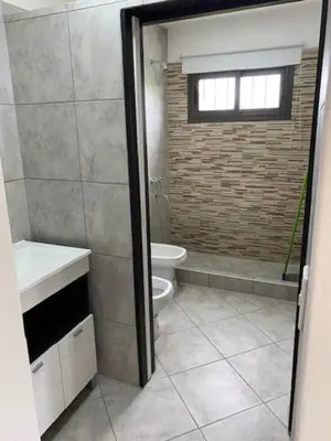 a bathroom with a toilet and a sink and a window at Cabaña Siete Colores II in Santa Rosa de Calamuchita