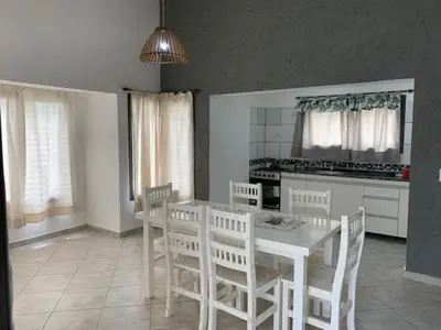 a kitchen with a table and chairs and a kitchen with a stove at Cabaña Siete Colores II in Santa Rosa de Calamuchita