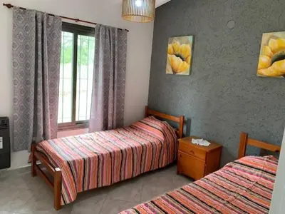 a hotel room with two beds and a window at Cabaña Siete Colores II in Santa Rosa de Calamuchita