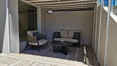 a patio with a couch and a table on a deck at Amérian Córdoba in Cordoba