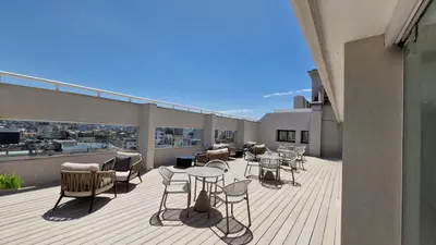 a balcony with chairs and tables on a building at Amérian Córdoba in Cordoba