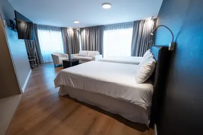 a hotel room with a large bed and a chair at Amérian Córdoba in Cordoba