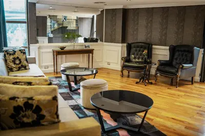 a living room with chairs and a couch and tables at Amérian Córdoba in Cordoba
