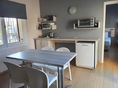 a kitchen with a table and chairs and a microwave at LA AMISTAD-CIUDAD UNIVERSITARIA- HOSPITAL FERREYRA in Cordoba