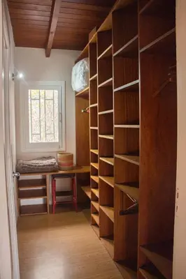 a room with a closet with wooden shelves and a window at LA AMISTAD-CIUDAD UNIVERSITARIA- HOSPITAL FERREYRA in Cordoba