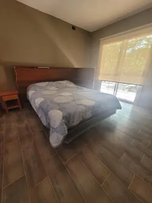 a bedroom with a bed and a wooden floor at Casa Tio Molina in Bialet Massé