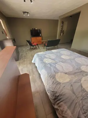 a large bed in a room with chairs and a table at Casa Tio Molina in Bialet Massé