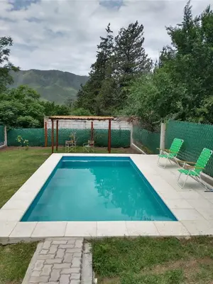 a swimming pool with two chairs and a gazebo at Casa Tio Molina in Bialet Massé