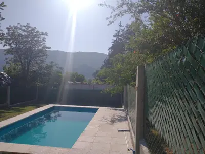 a swimming pool in front of a fence with the sun at Casa Tio Molina in Bialet Massé