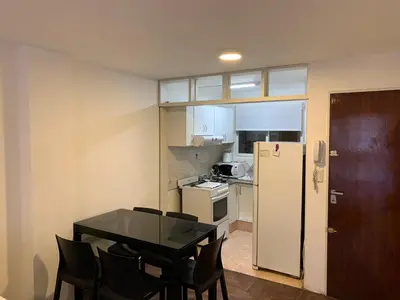 a kitchen with a table and chairs and a refrigerator at Pueyrredon 40, Nueva Cordoba in Cordoba