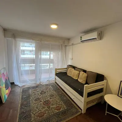 a bed in a room with a window and a couch at Pueyrredon 40, Nueva Cordoba in Cordoba