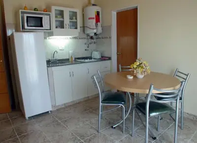 a kitchen with a table and chairs and a refrigerator at BAHIA DEL LAGO in Villa Carlos Paz