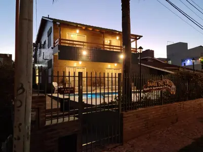 a house with a pool in front of a fence at BAHIA DEL LAGO in Villa Carlos Paz