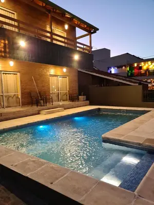 a swimming pool with blue lights in front of a building at BAHIA DEL LAGO in Villa Carlos Paz