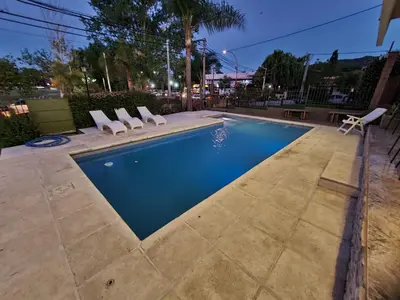 a swimming pool with lounge chairs and a table at BAHIA DEL LAGO in Villa Carlos Paz
