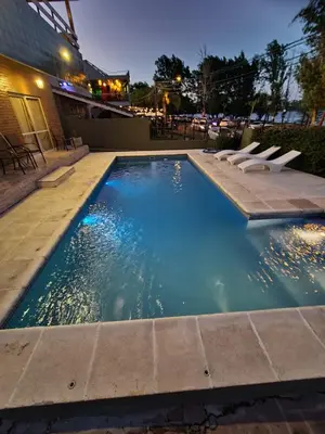 a swimming pool with lounge chairs in a building at BAHIA DEL LAGO in Villa Carlos Paz