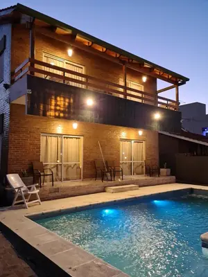 a house with a swimming pool in front of a building at BAHIA DEL LAGO in Villa Carlos Paz