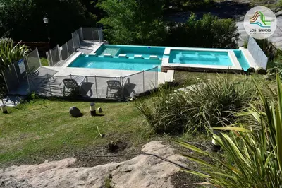 a large swimming pool in a yard with a yard at APART CABAÑAS LOS SAUCES in Tanti