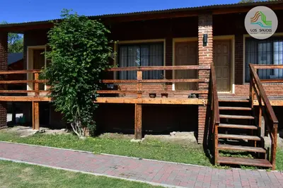 a house with a wooden porch and stairs to the entrance at APART CABAÑAS LOS SAUCES in Tanti