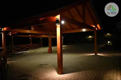 a wooden pavilion with a light on it at night at APART CABAÑAS LOS SAUCES in Tanti