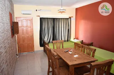 a dining room with a wooden table and chairs at APART CABAÑAS LOS SAUCES in Tanti