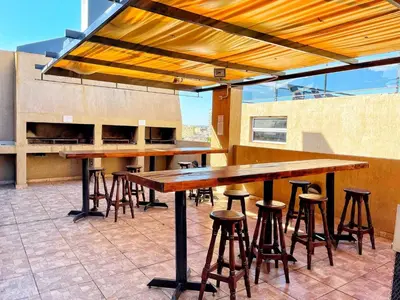 a group of tables and stools on a patio at Departamentos Miralejos 6 in Villa Carlos Paz