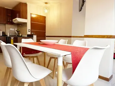 a dining room with a table and white chairs at Departamentos Miralejos 6 in Villa Carlos Paz
