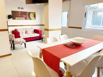 a dining room with a red table and white chairs at Departamentos Miralejos 6 in Villa Carlos Paz