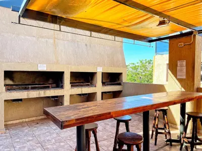 a bar with a wooden table and some stools at Departamentos Miralejos 6 in Villa Carlos Paz