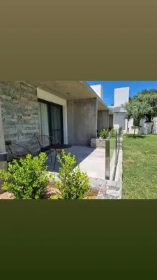 a view of a house with a stone wall and plants at Favre Suites in Mina Clavero