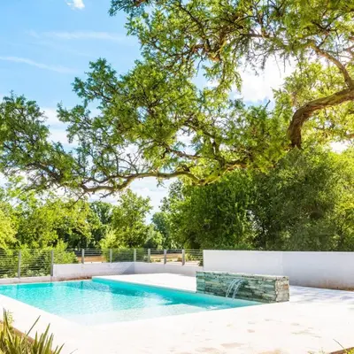 a swimming pool in a yard with a tree at Favre Suites in Mina Clavero