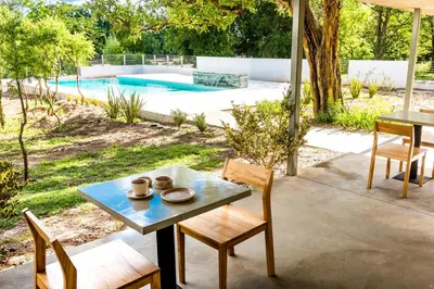 a patio with a table and chairs and a pool at Favre Suites in Mina Clavero