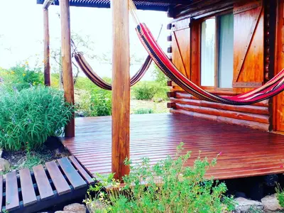 a wooden deck with a hammock and a bench at Monte Sion cabañas & relax in San Javier