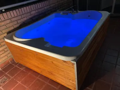 a large blue bath tub sitting next to a brick wall at HERMOSO DÚPLEX DE CATEGORÍA COMPLETAMENTE EQUIPADO in Cordoba