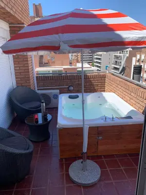 a hot tub with an umbrella on a patio at HERMOSO DÚPLEX DE CATEGORÍA COMPLETAMENTE EQUIPADO in Cordoba