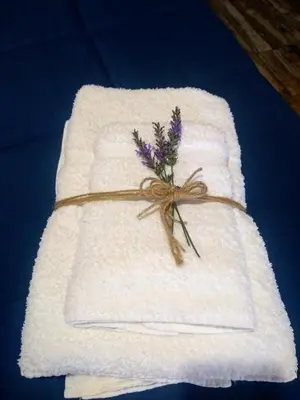 a white towel with a bouquet of flowers on it at Cabañas Tierra del Sol in Las Rabonas