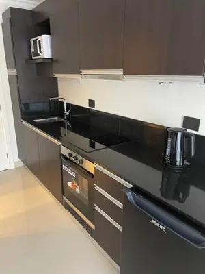 a kitchen with black counter tops and appliances at Apart France - Monoambiente con piscina y estacionamiento in Río Cuarto