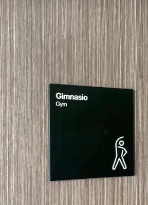 a black sign on a wooden wall with a person at Apart France - Monoambiente con piscina y estacionamiento in Río Cuarto